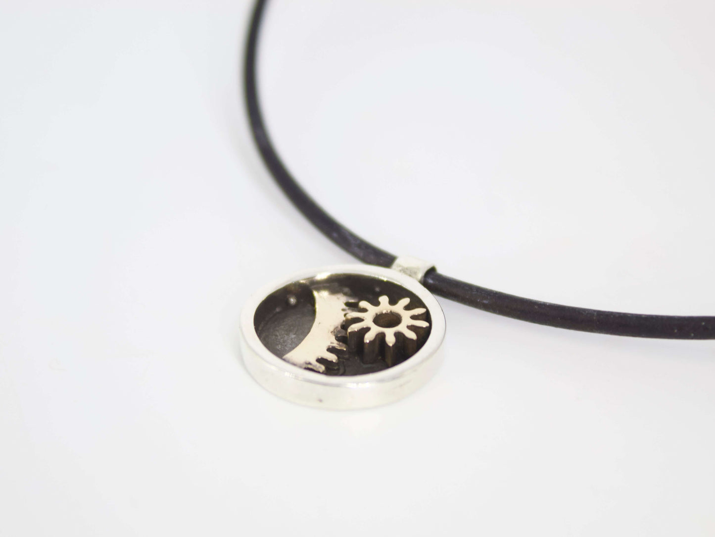 Ciondolo tondo stile steampunk Glimoire con ingranaggi metallici su cordino nero minimalista