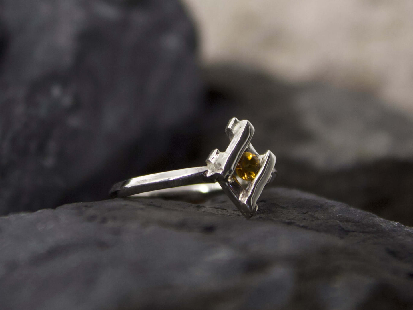Anellino pietra gialla Glimoire con design elegante in argento su fondo scuro