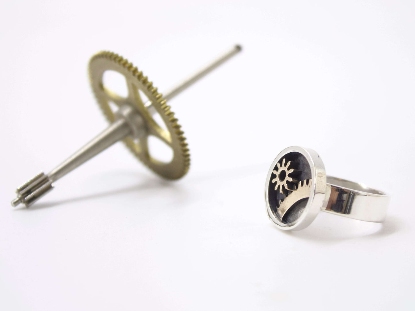 Anello ingranaggi steampunk in argento con design meccanico su sfondo bianco di Glimoire