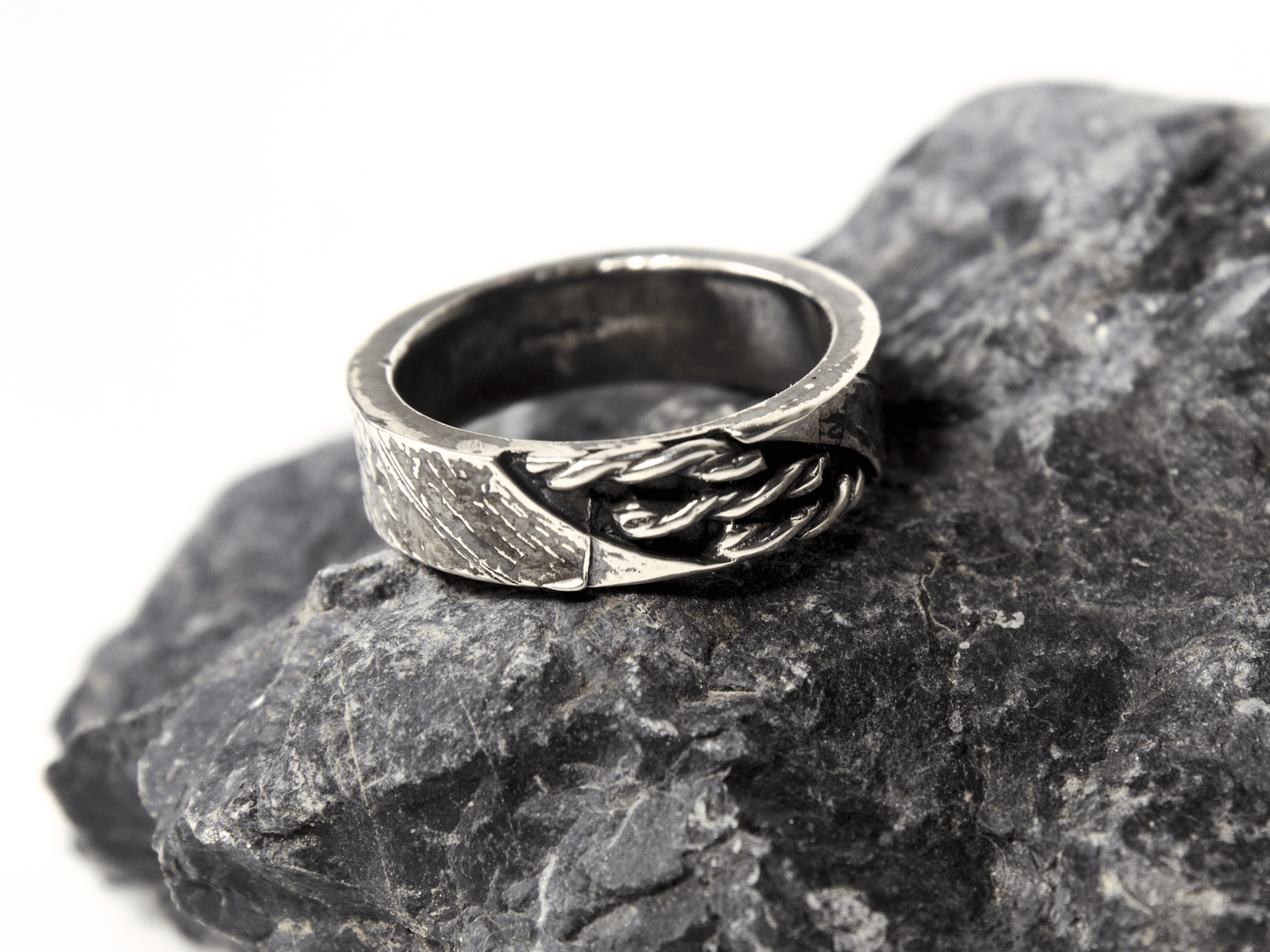 Anello intrecciato oreficeria tradizionale in argento su pietra scura per un look sofisticato