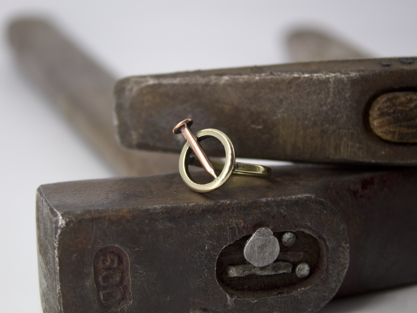 Anello chiodo Glimoire in metallo bicolore foto su incudine e martello gioiello artigianale minimal