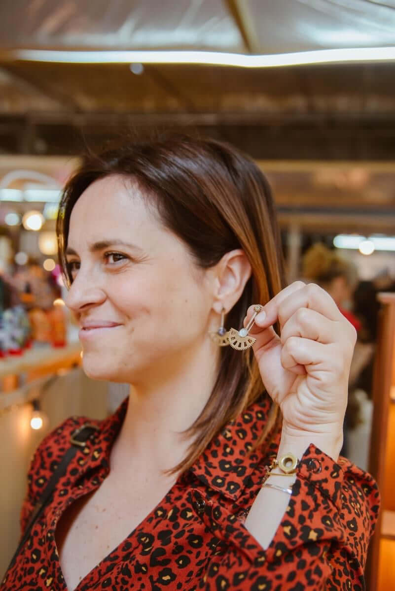 Donna che sorride indossando orecchini pendenti pietra naturale Glimoire a forma di ventaglio