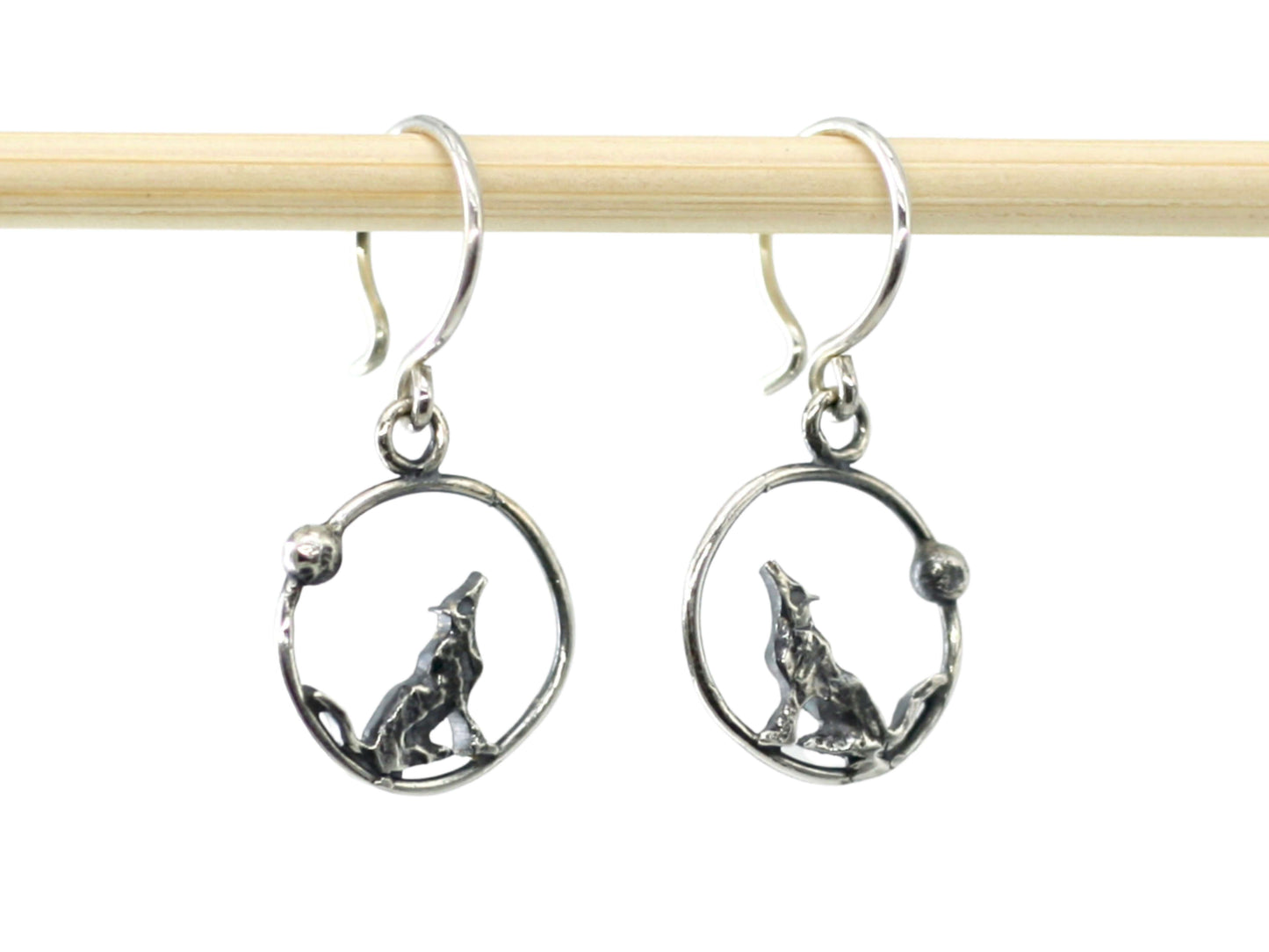 Orecchini lupi incisi a mano in argento con design di lupo che ulula dentro cerchio di Glimoire