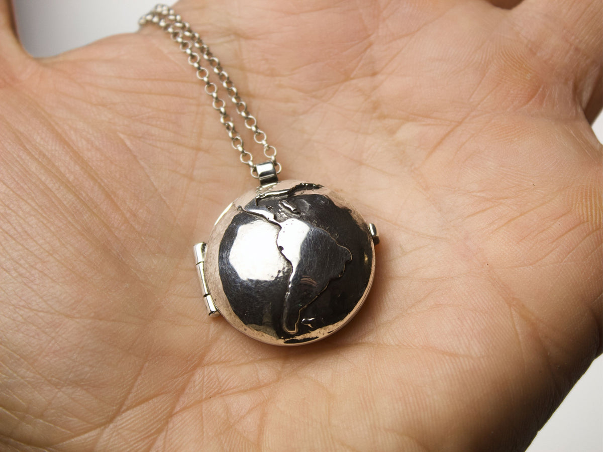 Collana Glimoire con pendente Portafoto mondo a forma di globo terrestre in una mano