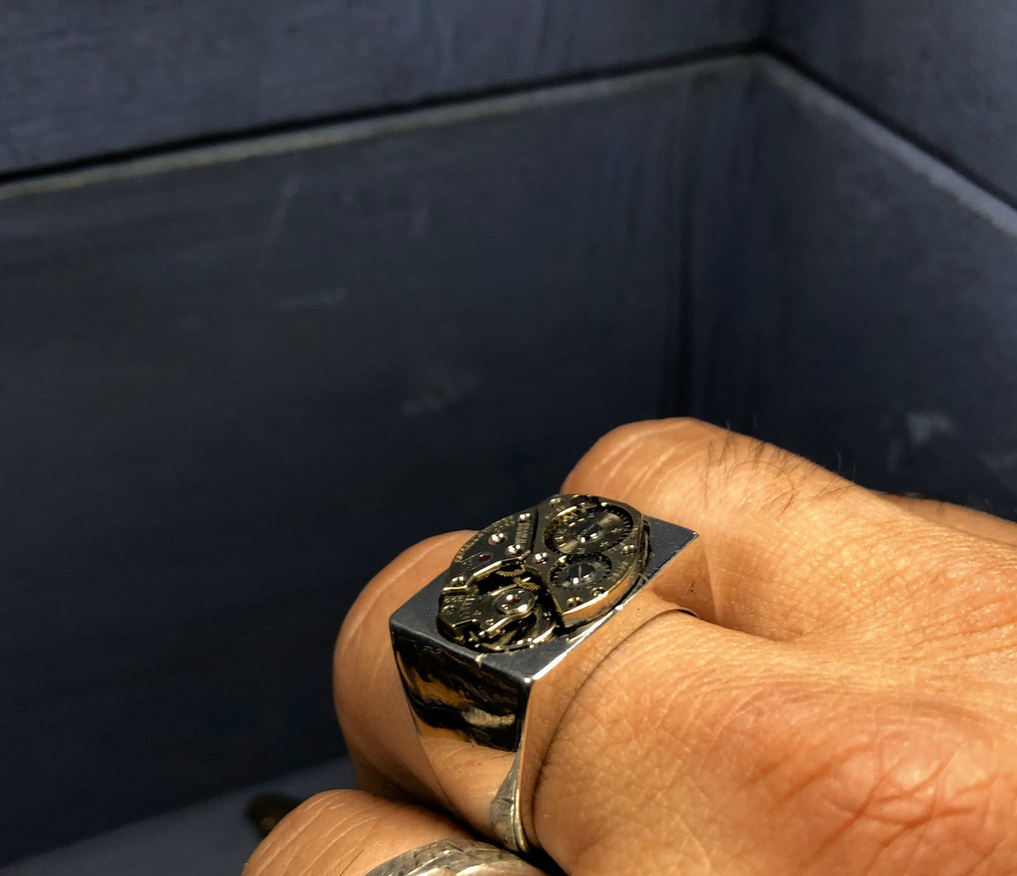 Anello in argento con meccanismo di design quadrato indossato su mano maschile