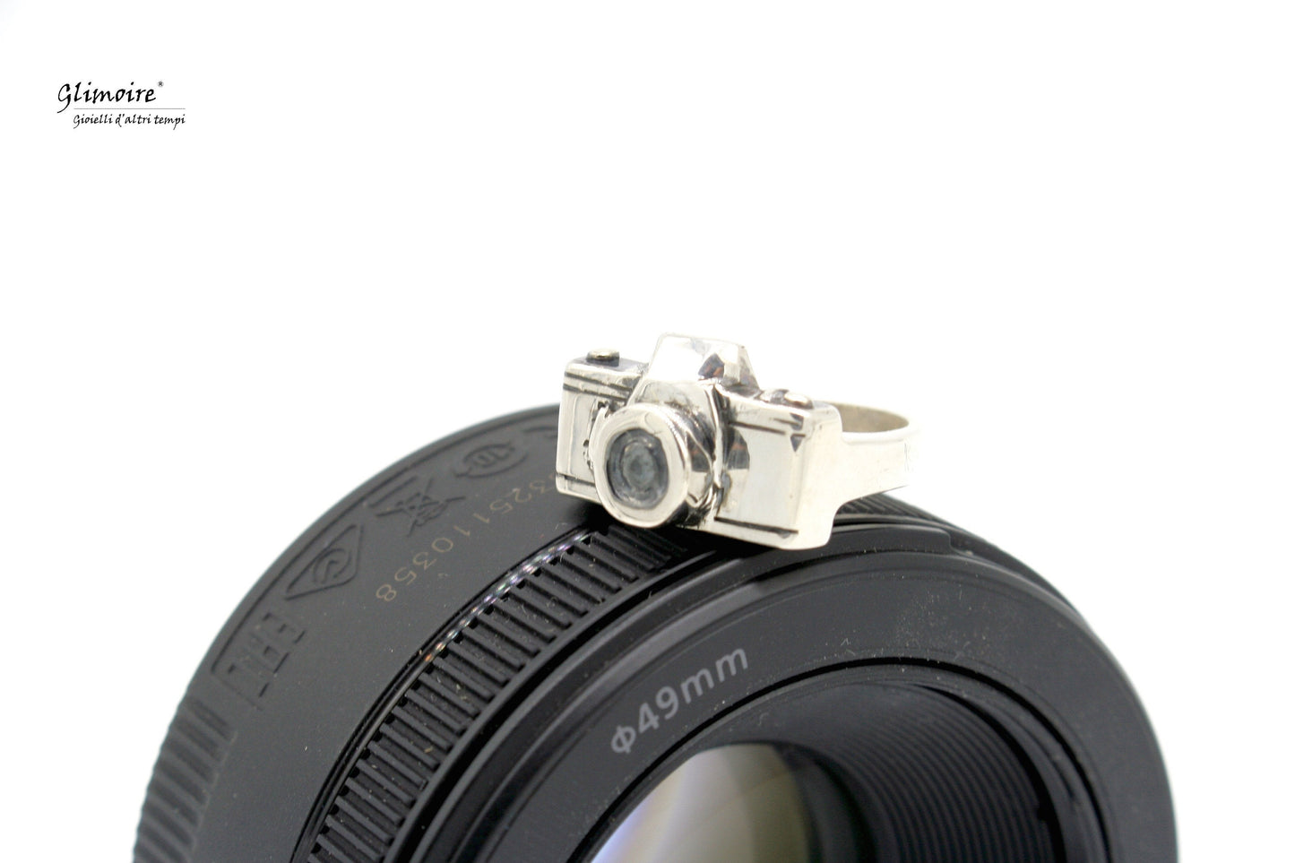 Anello fotocamera in argento di Glimoire posto su lente fotografica nera