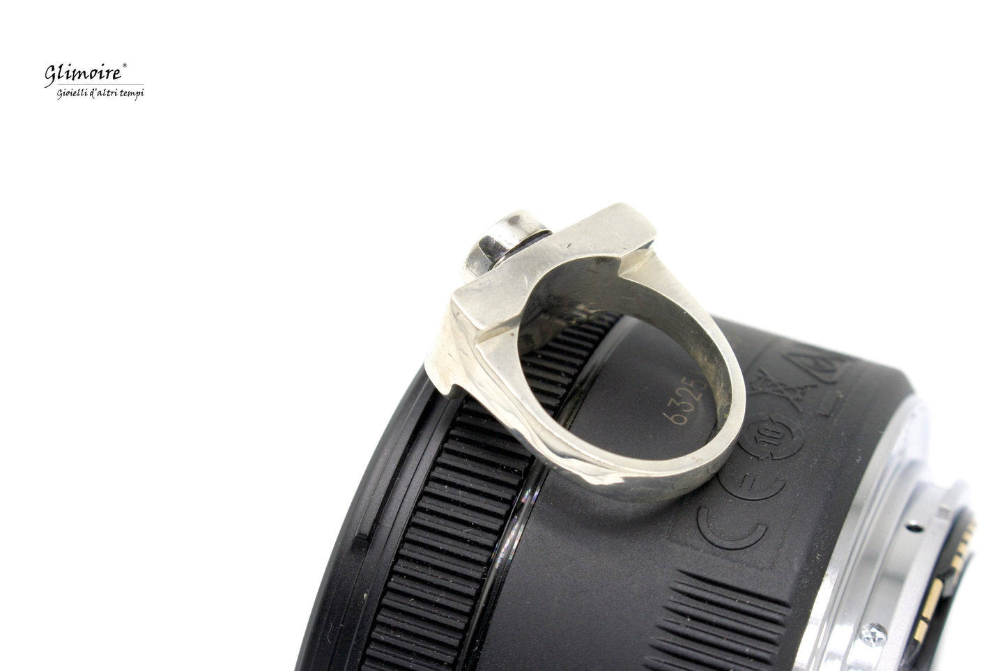 Anello fotocamera in argento Glimoire posizionato su un obiettivo fotografico nero