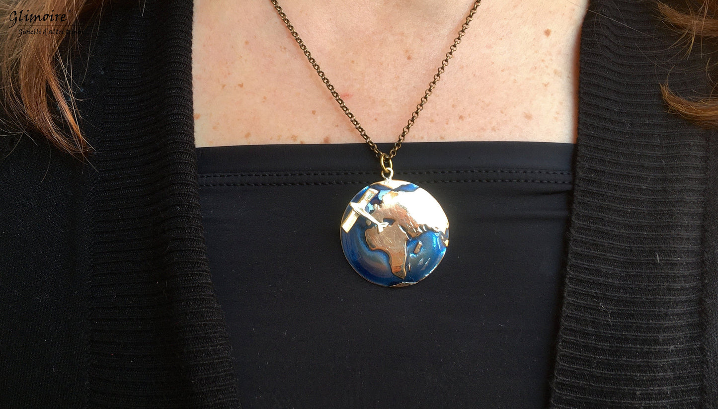Collana viaggio aereo artigianale Glimoire con pendente a forma di mappamondo indossata