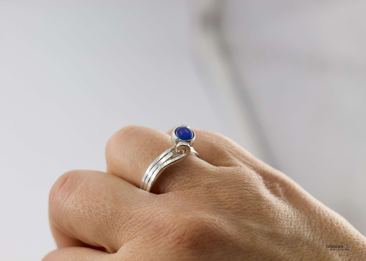 Anello in argento pietra blu Glimoire con castone tondo a cupola su sottile fedina lucida indossato