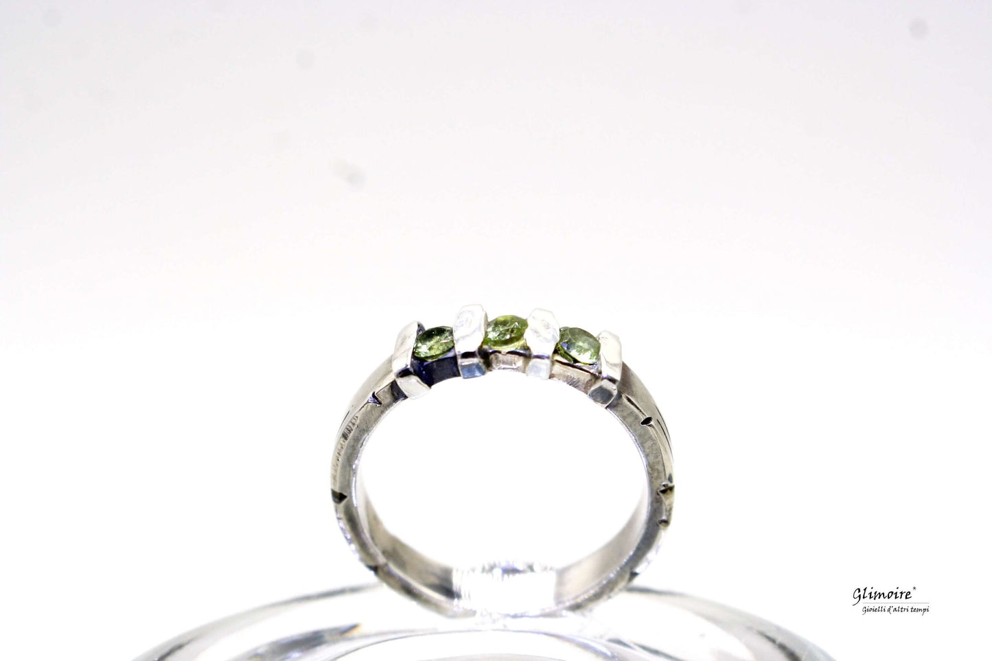 Anello ametista Glimoire con tre piccole pietre verdi su fascia in argento lucido
