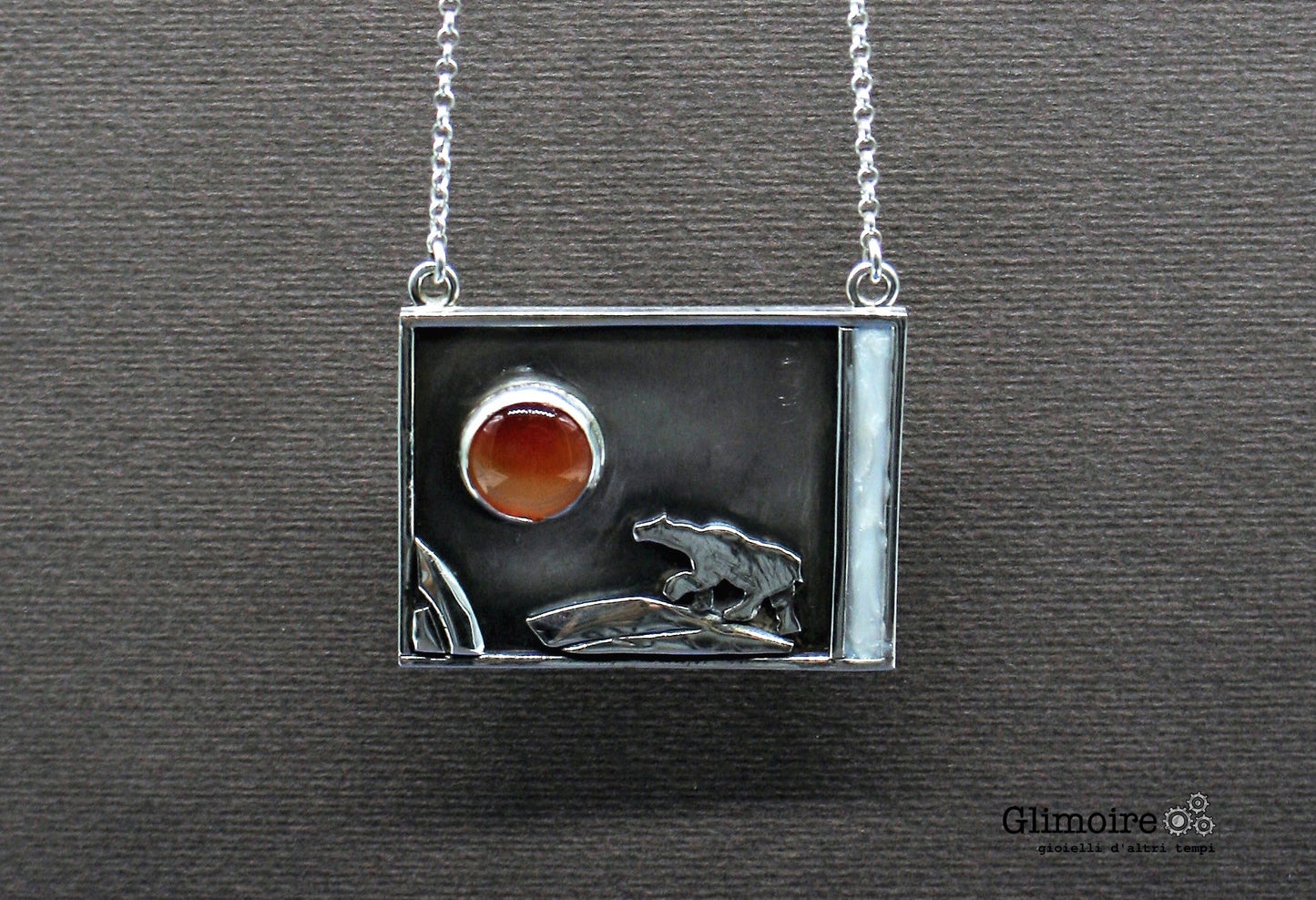 Collana orso polare Glimoire con ciondolo rettangolare in argento e pietra rossa su sfondo nero