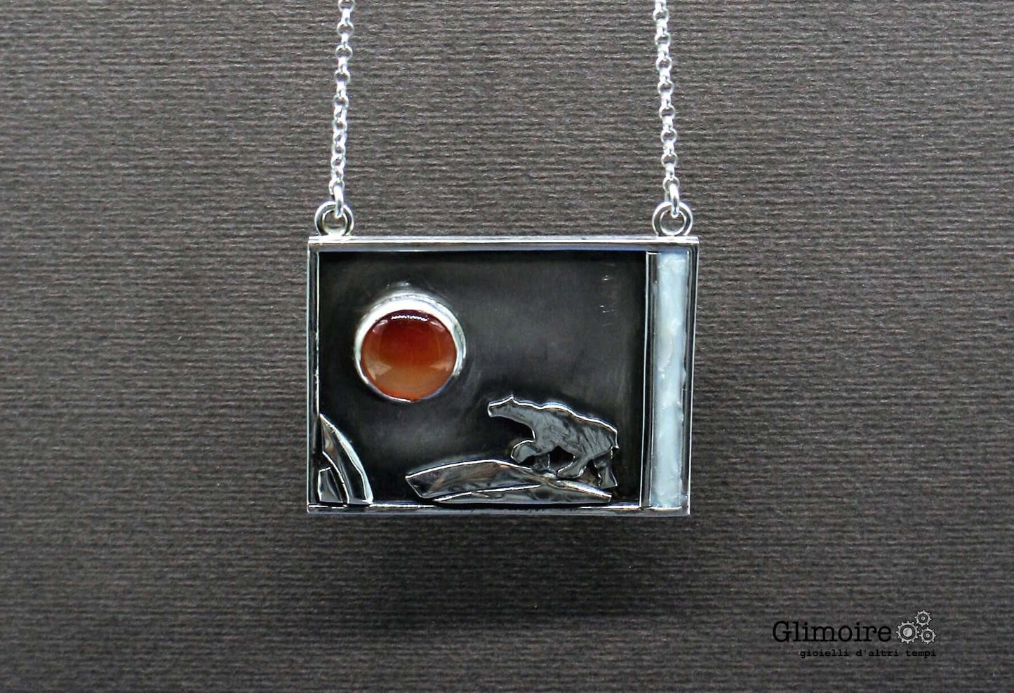 Collana orso polare Glimoire con ciondolo rettangolare in argento e pietra rossa su sfondo nero