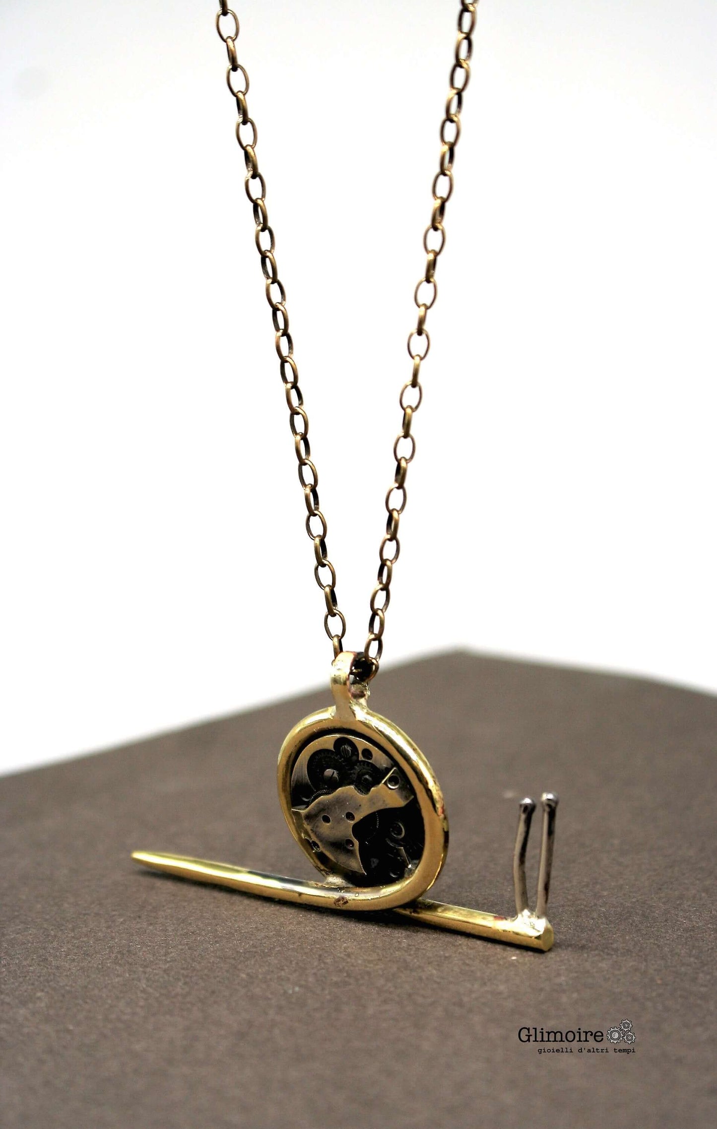 Collana chiocciola steampunk Glimoire con pendente a forma di chiocciola in metallo dorato e ingranaggi neri