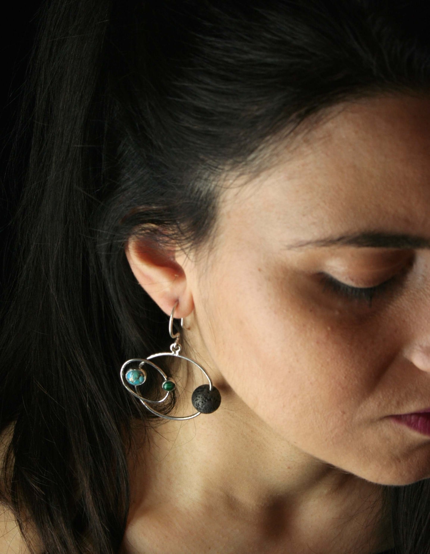 Orecchini artigianali pianeti indossati da donna con design a ispirazione spaziale e sfere colorate