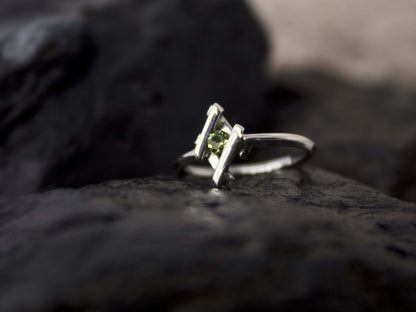 Elegante anellino in argento con pietra verde di Glimoire su sfondo scuro