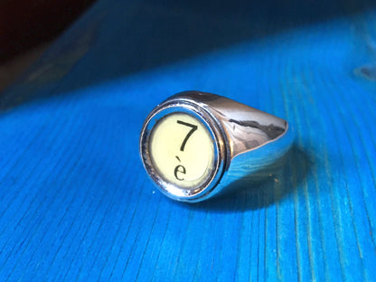 Anello a sigillo personalizzato in argento con incisione numero 7 su sfondo chiaro Glimoire