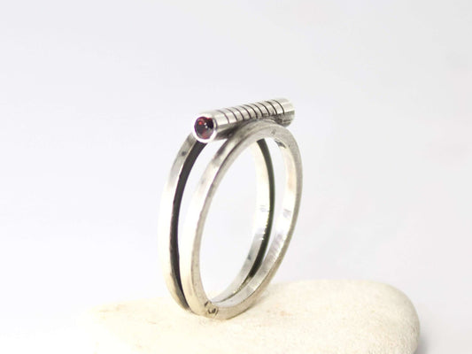 Anello Glimoire in argento con dettaglio a vite e piccolo rubino incastonato