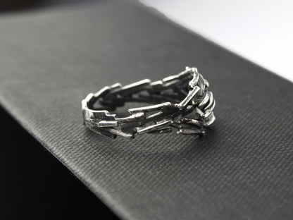 L'anello Gestalt di Glimoire, realizzato con frammenti d'argento saldati, ha una finitura brunita e lucida.