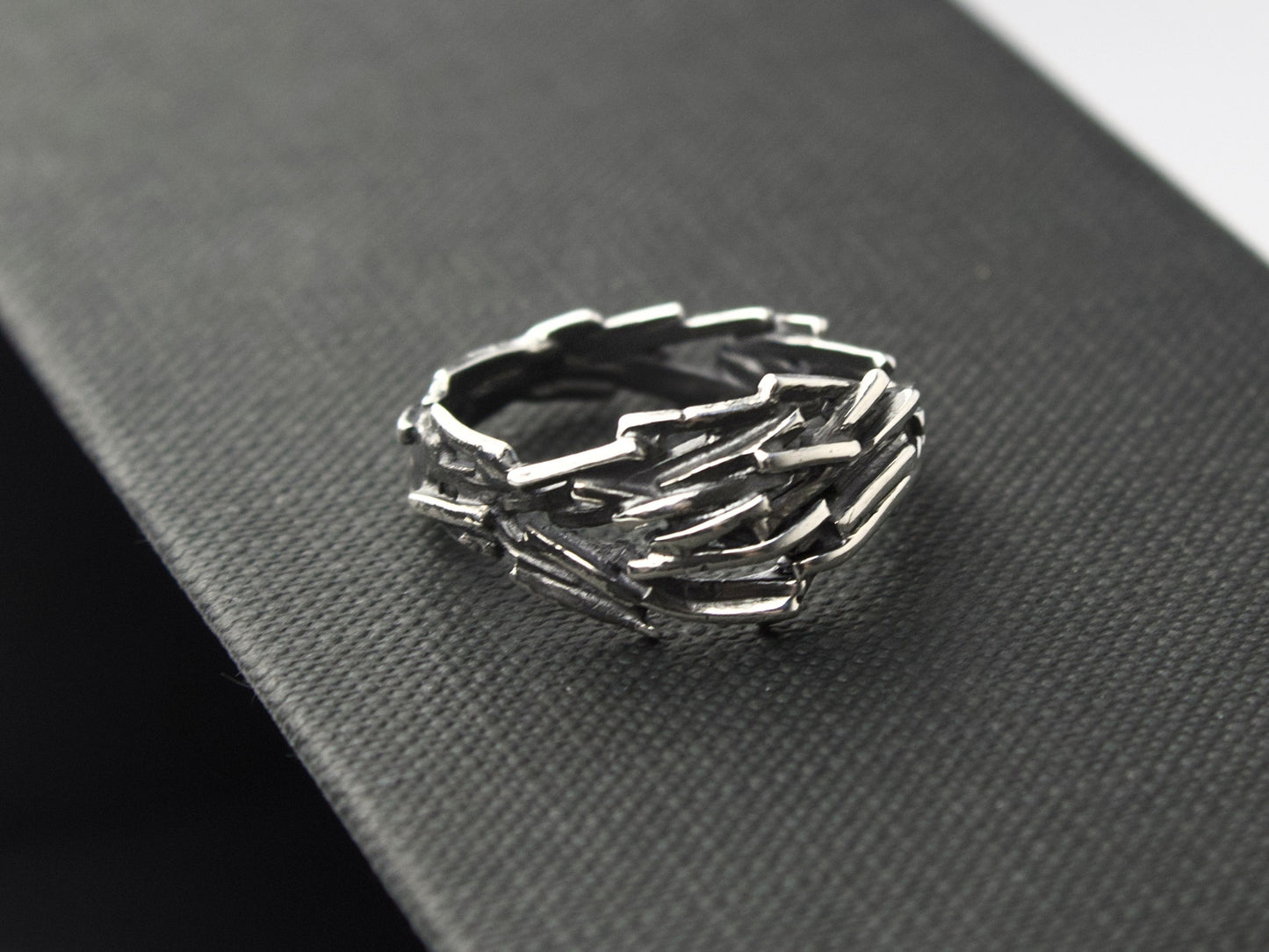 L'anello Gestalt di Glimoire è composto da piccole parti d'argento saldati insieme, con finitura brunita e lucida.
