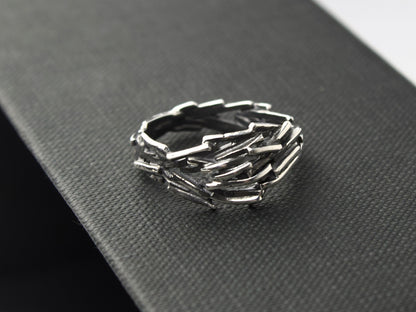 L'anello Gestalt di Glimoire è composto da piccole parti d'argento saldati insieme, con finitura brunita e lucida.