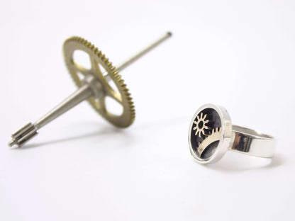 Anello ingranaggi steampunk in argento con design meccanico su sfondo bianco di Glimoire
