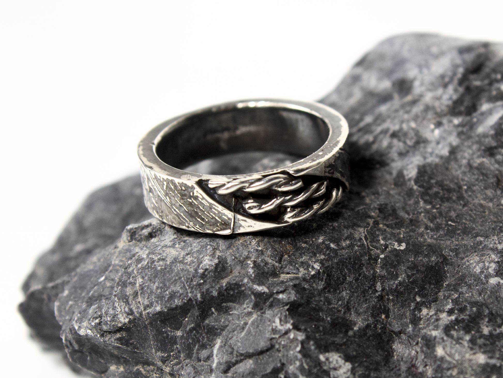 Anello intrecciato oreficeria tradizionale in argento su pietra scura per un look sofisticato