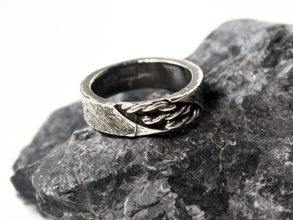 Anello intrecciato oreficeria tradizionale in argento su pietra scura per un look sofisticato