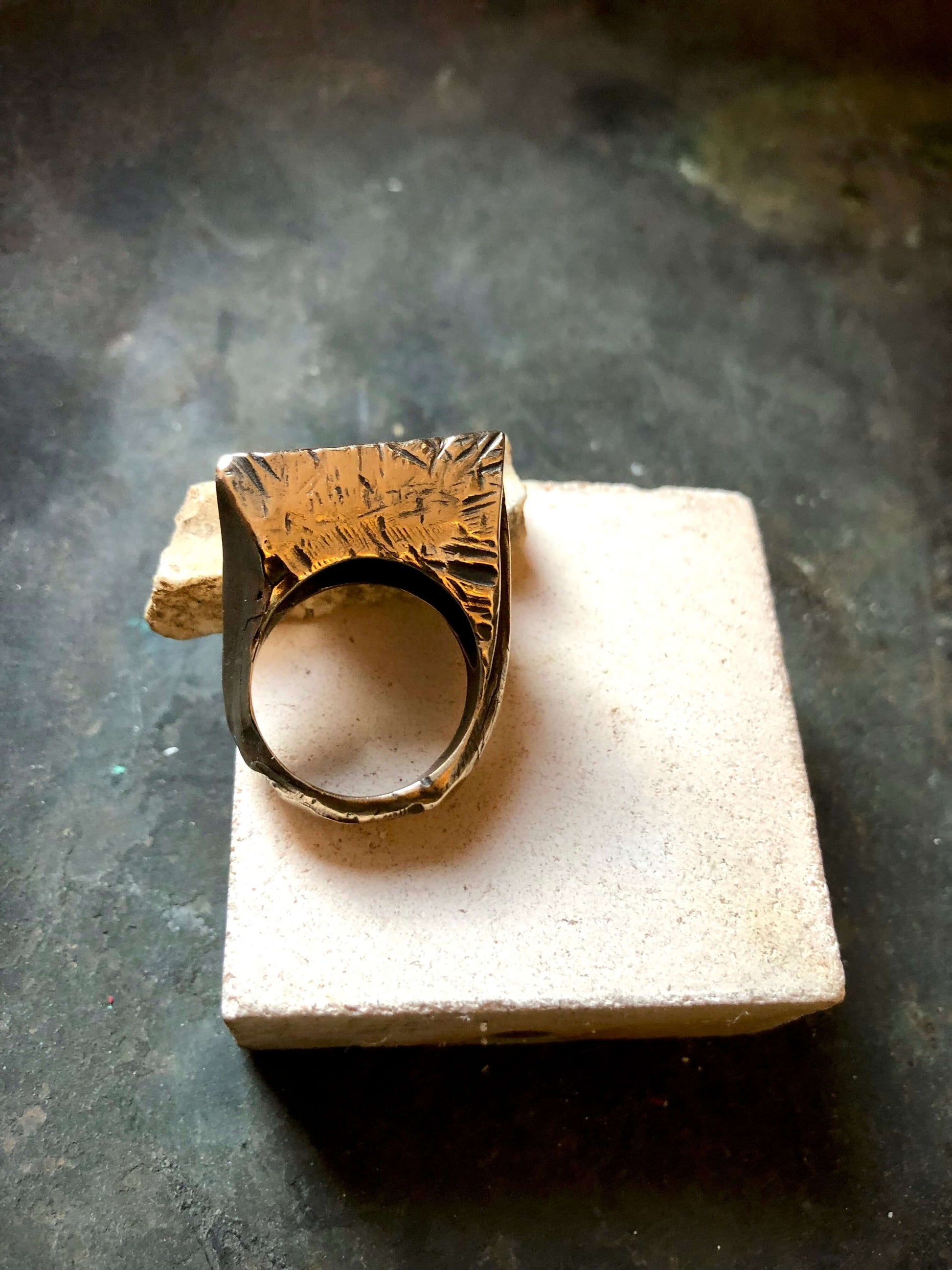 Anello materico in bronzo con design artistico di Glimoire su base di pietra chiara