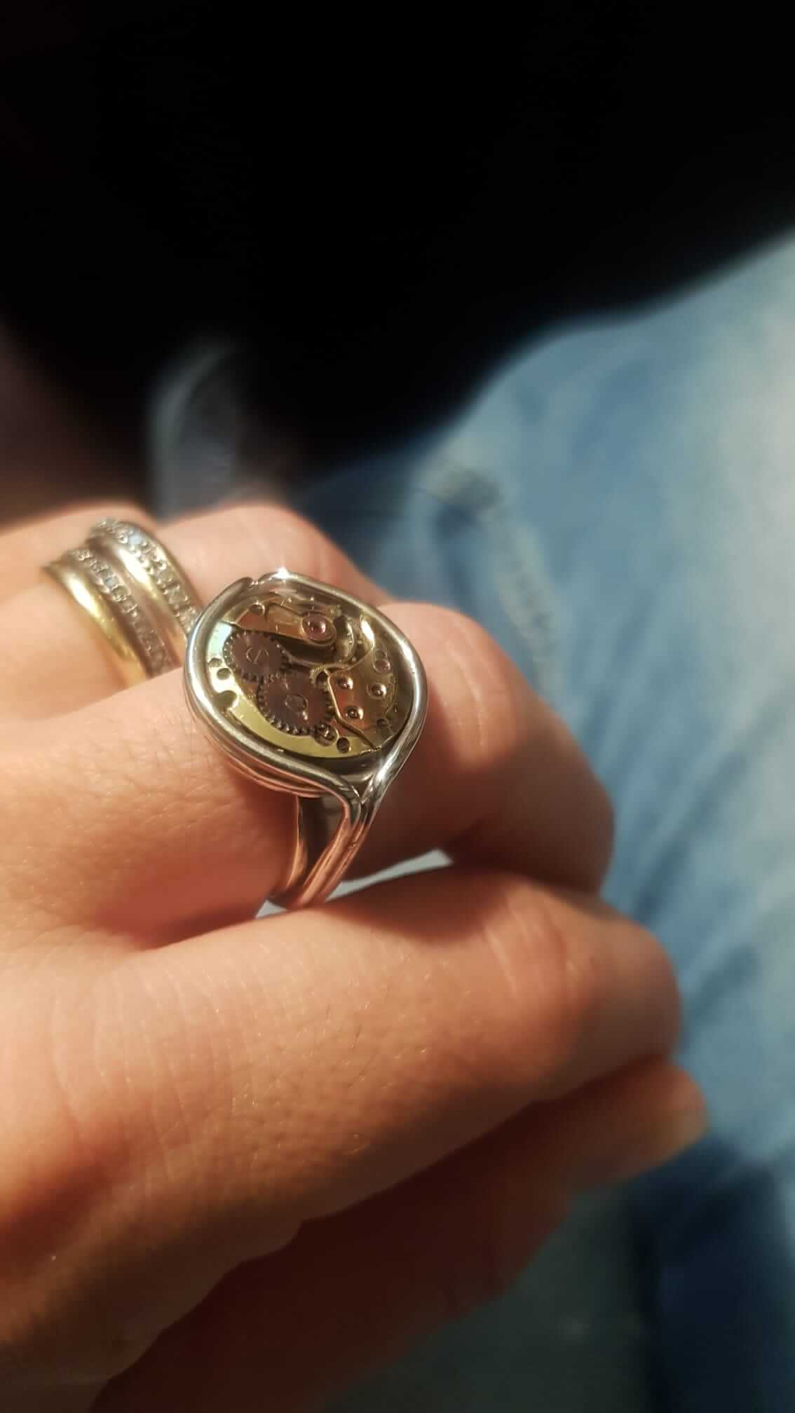 Anello artigianale con ingranaggi di orologio vintage indossato sulla mano