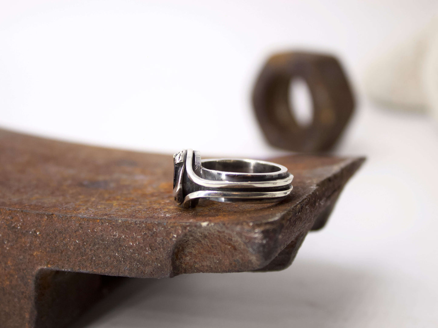 Anello da uomo in onice di Glimoire in argento con design moderno su superficie rustica