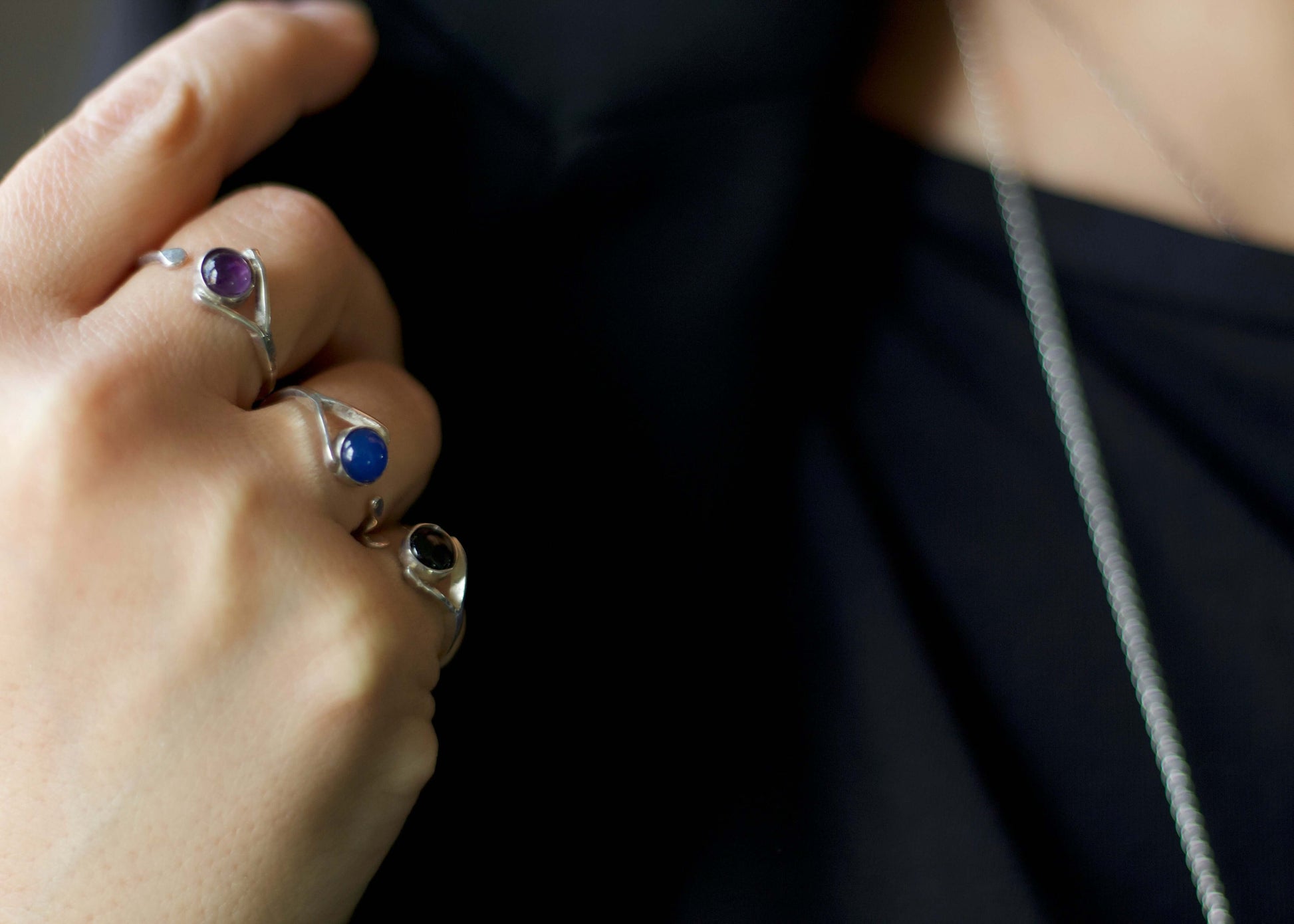 Anellino ametista Glimoire in argento indossato insieme ad altri anelli con pietre blu e nere