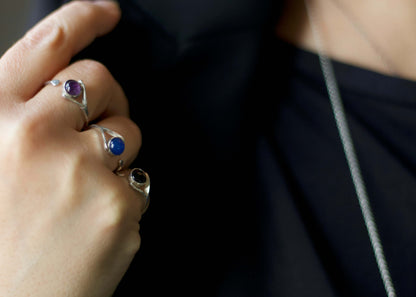 Anellino ametista Glimoire in argento indossato insieme ad altri anelli con pietre blu e nere