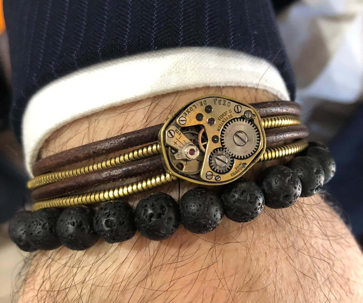 Bracciale artigianale meccanismo di orologio in cuoio e snake in ottone. Foto con bracciale indossato