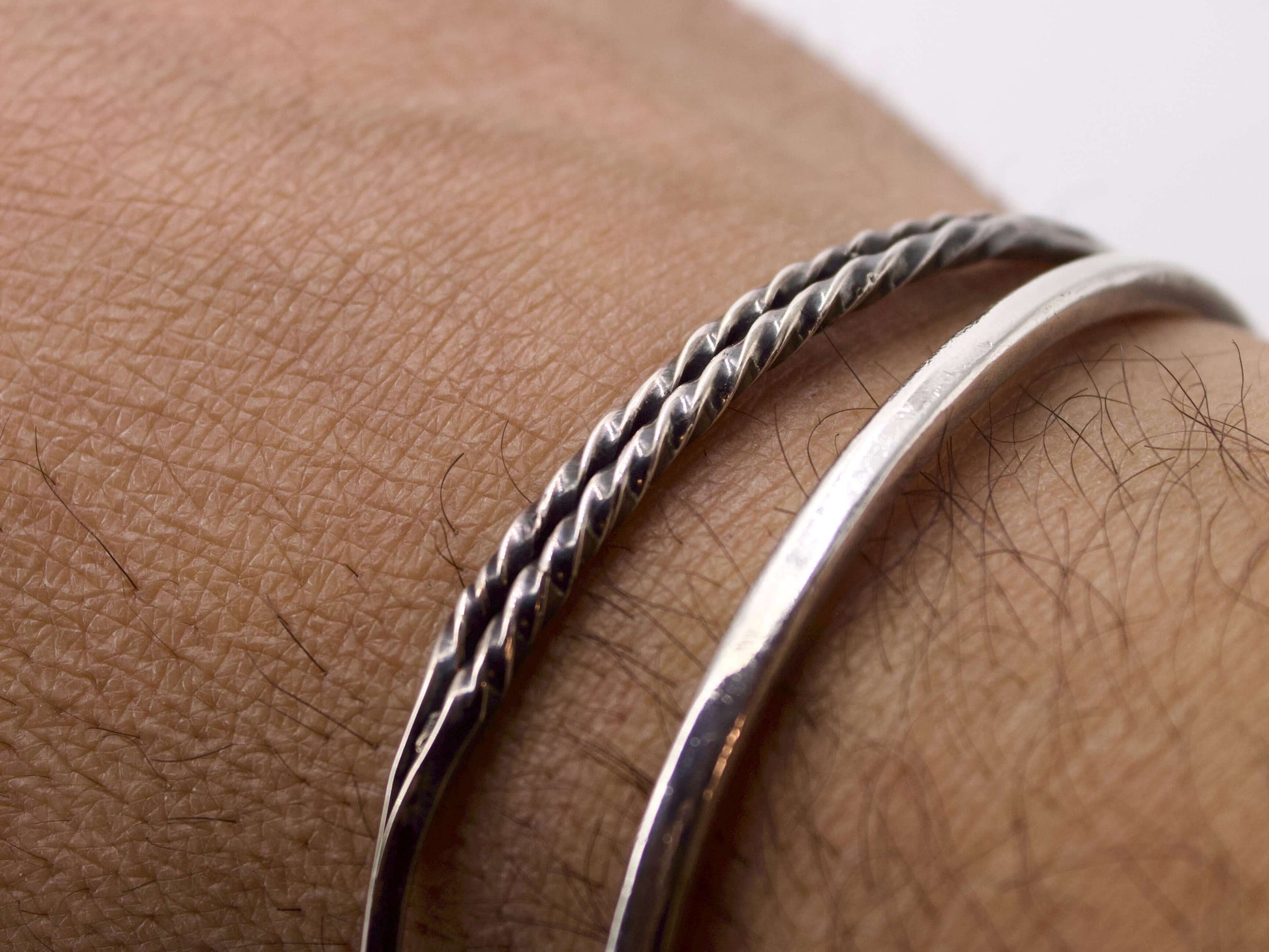 Bracciale in argento intrecciato Glimoire indossato al polso con design elegante e moderno