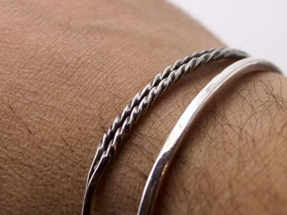 Bracciale in argento intrecciato Glimoire indossato al polso con design elegante e moderno