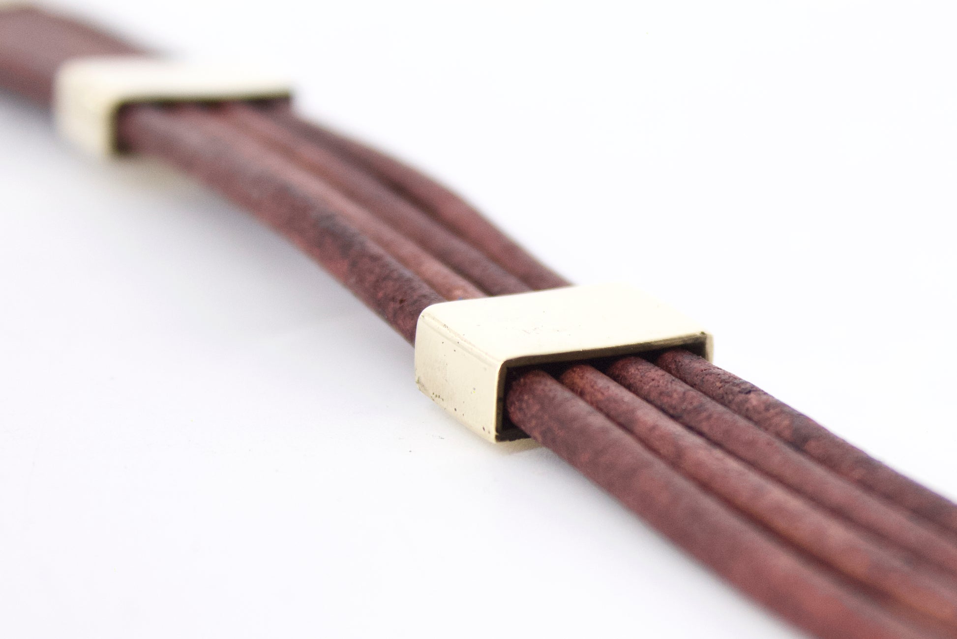Bracciale Glimoire con fili di cuoio marrone e dettagli in metallo dorato elegante