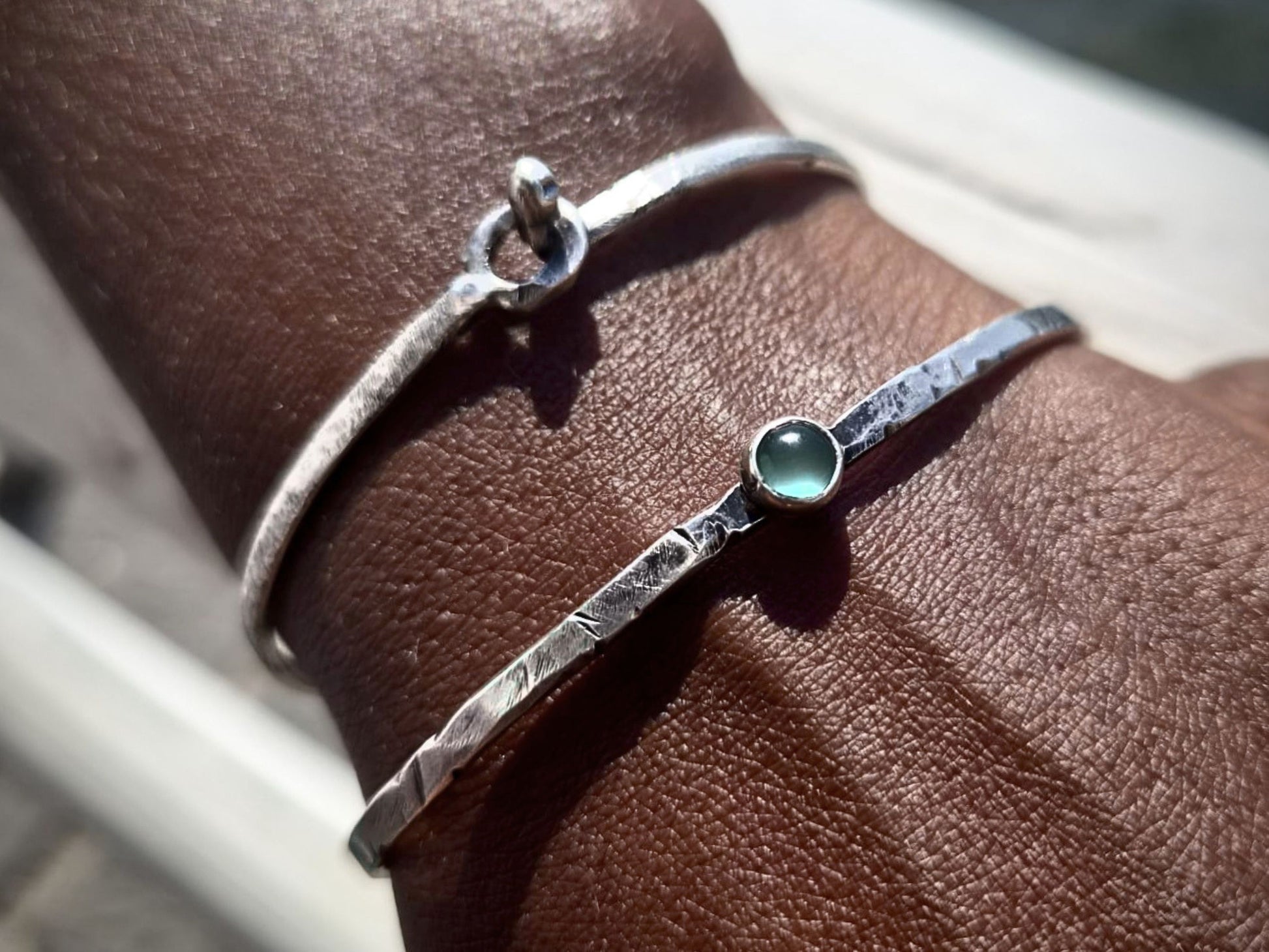Bracciale rigido in argento Pietra e Acqua indossato su un polso con dettagli eleganti