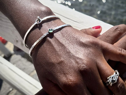 Bracciale rigido in argento Pietra e Acqua indossato su un polso elegante vicino all'acqua
