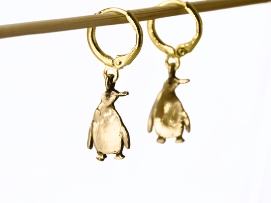 Bronze penguin earrings with golden hoops, handcrafted and unique, perfect for nature and artisan jewelry lovers.