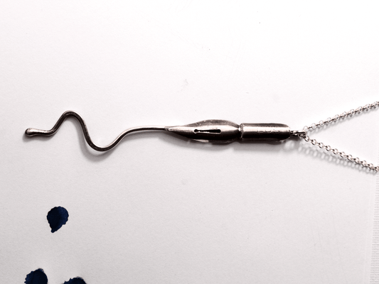 Collana artigianale con ciondolo pennino d'epoca da scrittura su sfondo bianco