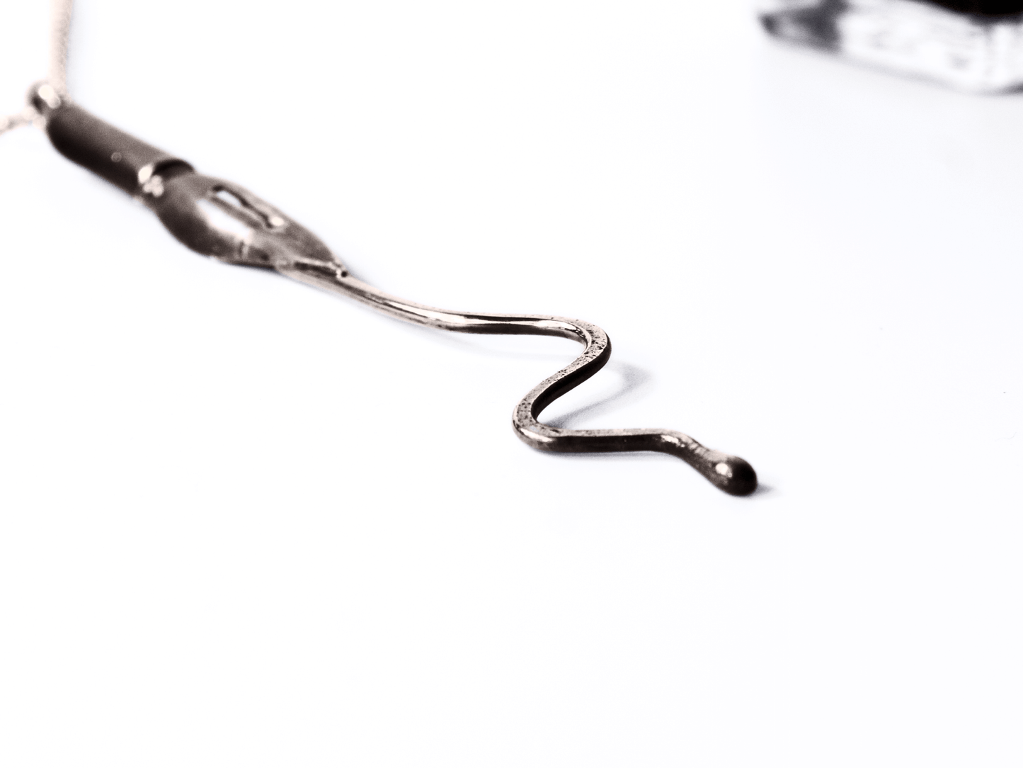 Collana artigianale con ciondolo pennino d'epoca da scrittura in primo piano su sfondo bianco