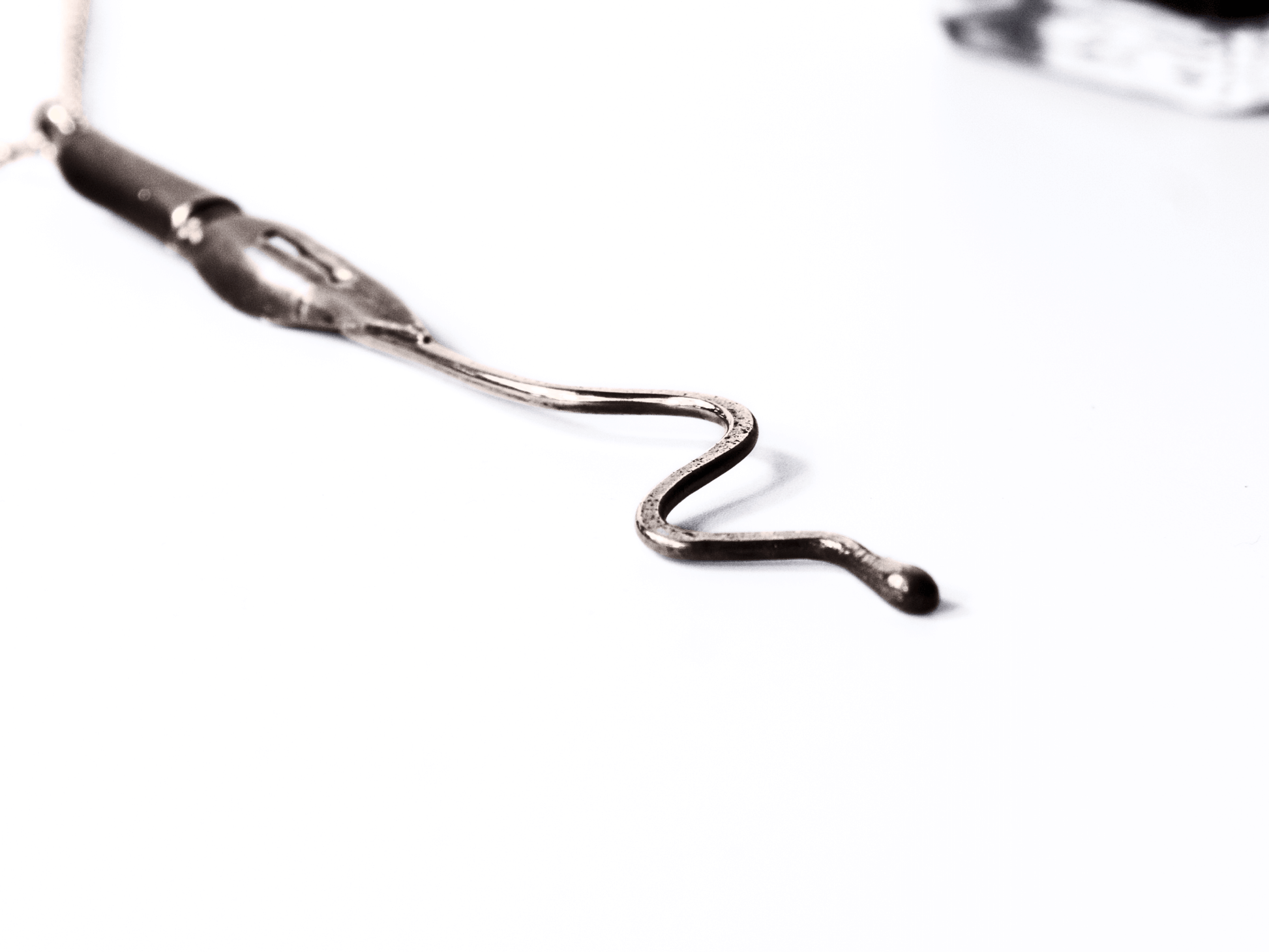 Collana artigianale con ciondolo pennino d'epoca da scrittura in primo piano su sfondo bianco