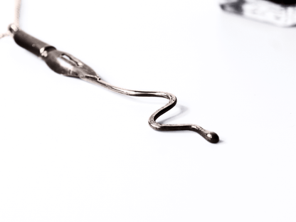 Collana artigianale con ciondolo pennino d'epoca da scrittura in primo piano su sfondo bianco