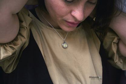 Collana con tasti di macchina da scrivere indossata da donna con ciondolo tondo su catena sottile