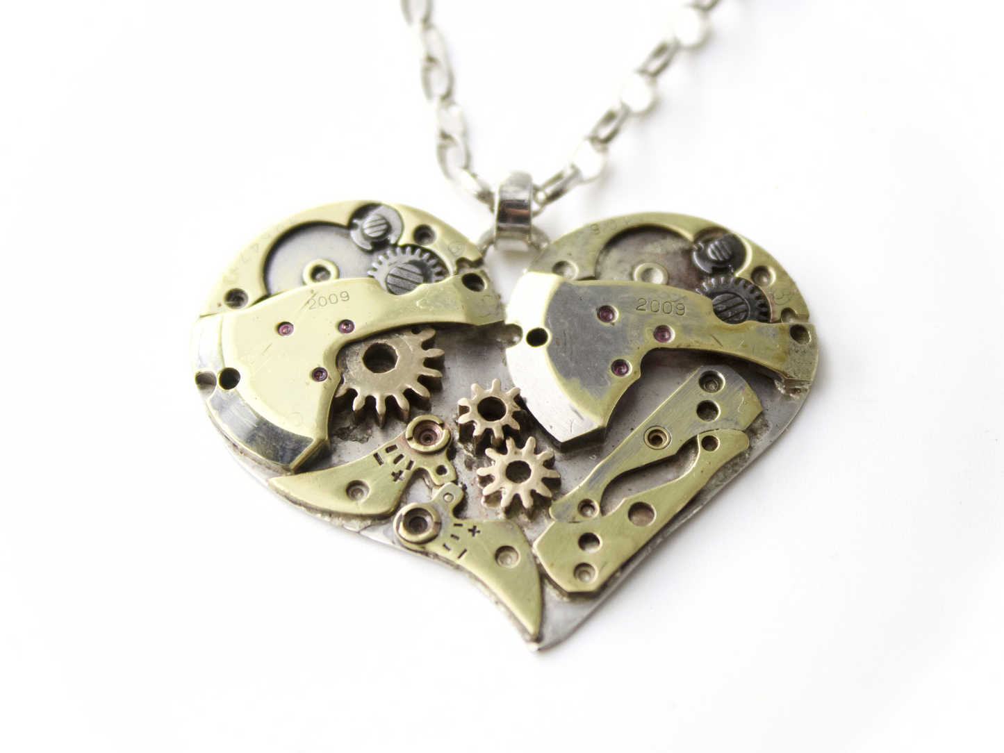 Collana cuore meccanico argento con ingranaggi visibili all'interno del pendente a forma di cuore