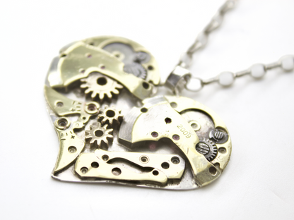 Collana cuore meccanico argento con ingranaggi in oro e dettaglio del ciondolo a forma di cuore