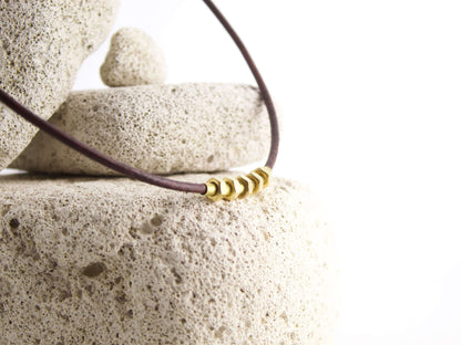 Collana dadi e bulloni in ottone su cordino di cuoio 