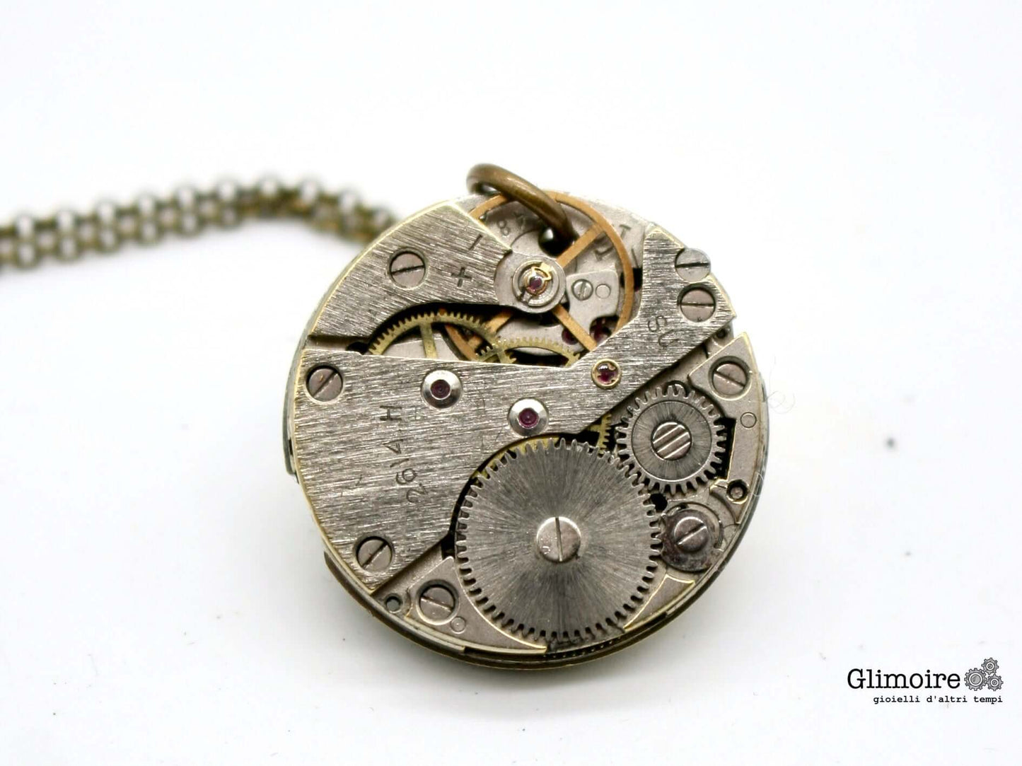 Collana Glimoire con meccanismo di orologio a carica manuale degli anni '50, dettagli visibili degli ingranaggi.