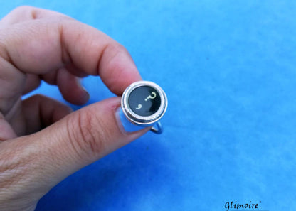 Anello artigianale con tasto di macchina da scrivere in bachelite indossato al dito