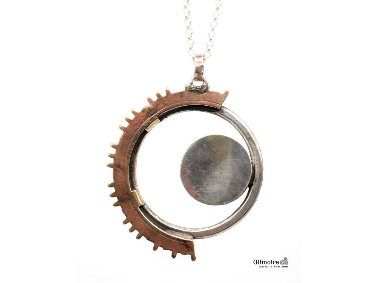 Dettaglio della sagoma di luna e ingranaggi di orologio a pendolo